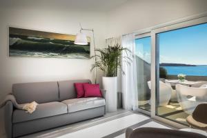 een woonkamer met een bank en uitzicht op de oceaan bij Rivalmare Boutique Hotel in Novigrad Istria