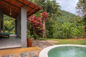a swimming pool next to a house with a garden at Sítio casa das fadas em Pacoti in Pacoti