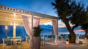 a restaurant with tables and chairs in front of the ocean at Rivalmare Boutique Hotel in Novigrad Istria