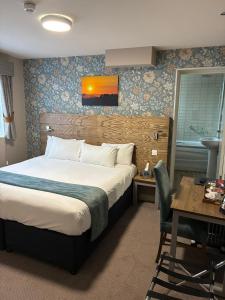 a hotel room with a bed and a desk and a sink at Ye Olde Griffin in March