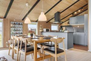 a kitchen and dining room with a table and chairs at 6606-Hvide-Sande-Arvidvej-164 in Bjerregård