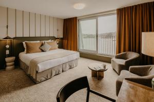 a hotel room with a bed and a chair at Maison LE GOYEN & Spa in Audierne +48 photos