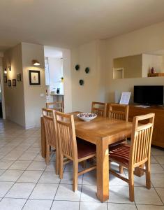 a dining room with a wooden table and chairs at Made in Langhe Apartment in La Morra
