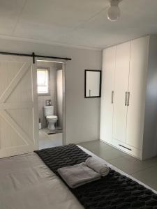 a bathroom with a bed with a sliding door at Cottage @19th in Pretoria