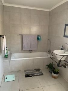 a bathroom with a bath tub and a sink at Cottage @19th in Pretoria +32 photos