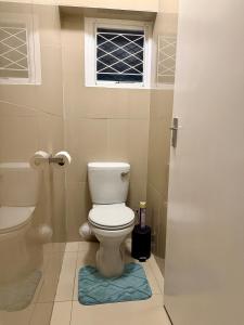 a bathroom with a toilet and a window at 2Bedroom Apartment in Pinetown +16 photos