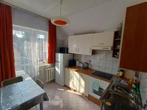 a kitchen with white cabinets and a table and a window at Apartamenty na skarpie in Szczecin +15 photos