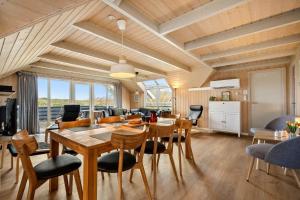 a dining room and living room with a table and chairs at 3395-Hvide-Sande-Fyrmarken-33 in Hvide Sande