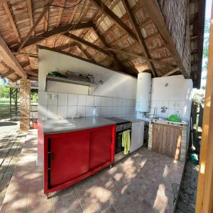 a kitchen with a red island in a pavilion at Rustic Harmony in Abádszalók