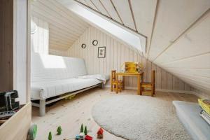 a attic room with a bed and a table at 3395-Hvide-Sande-Fyrmarken-33 in Hvide Sande