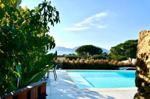 a swimming pool in a villa with mountains in the background at Domaine LUMISTELLA in Porticcio