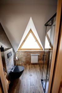 a bathroom with a black toilet and a window at Domki Pod Góralskim Niebem in Zakopane +48 photos