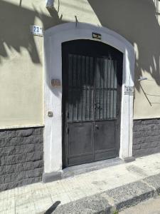 a black door in a building with a wall at La Nica in Catania