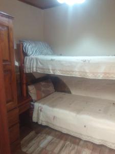 a bedroom with two bunk beds and a stool at Killa wasy in Humahuaca