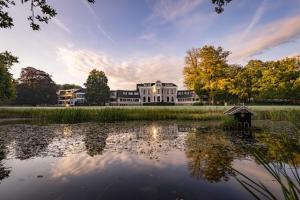 a large house with a pond in front of it at Landgoed Lauswolt in Beetsterzwaag