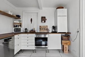 a kitchen with white cabinets and a refrigerator at 4221-Stege-Langgade-21 in Stege
