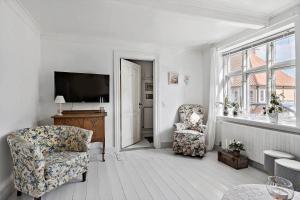 a living room with a chair and a television at 4221-Stege-Langgade-21 in Stege