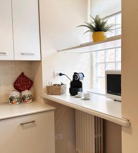 a kitchen counter with a microwave and a window at Made in Langhe Apartment in La Morra