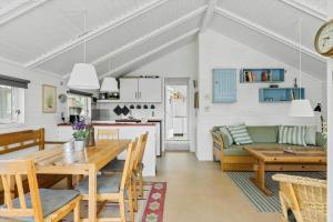 a kitchen and living room with a wooden table and chairs at 3054-Stege-Stejlepladsen-12 in Stege +13 photos