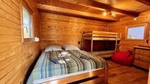 a bed in a cabin with a wooden wall at Rustic Harmony in Abádszalók