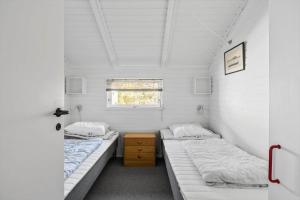two beds in a small room with a window at 3054-Stege-Stejlepladsen-12 in Stege