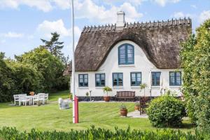 a large white house with a thatched roof at 6306-Stege-Hjelmvej-24 in Stege