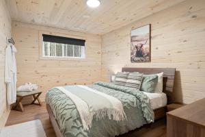 a log cabin bedroom with a bed and a window at Chalet Le Solem Golf et Spa in Saint-Faustin
