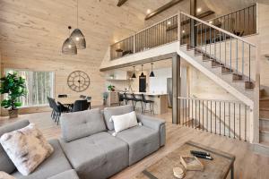 a living room with a couch and a staircase at Chalet Le Solem Golf et Spa in Saint-Faustin