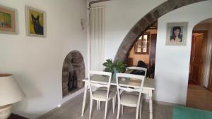 a dining room with a table and white chairs at Residenza Caterina in Bolsena