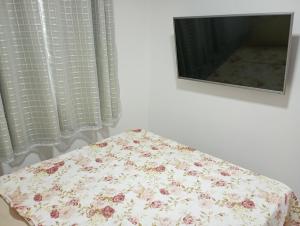 a table with a flowered pillow in front of a television at top Suites in Saquarema