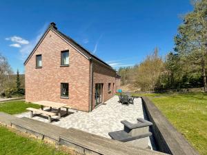 a brick building with benches in front of it at Villa Noach in Durbuy