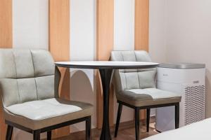 a table with two chairs and a table with a desk at CENTRO HOTEL - 안양iT단지, 군포제일공단 in Anyang