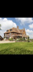 a large brick house with a green field in front of it at 16th Century Manor House in Richborough
