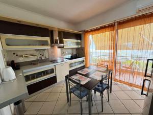 a kitchen with a table and chairs and a kitchen with a window at The Sea View kanali in Kanali