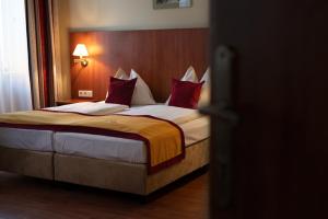 a bedroom with a large bed with red pillows at Hotel Mozart in Vienna +30 photos