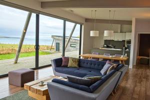 a living room with a blue couch and a large window at Jog Lodge 22 By Together Travel - 3 Bed Sea-View in Wick
