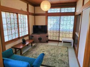 a living room with a blue couch and a tv at さくらVillaCOAST in Futtsu