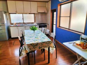 a kitchen with a table and chairs and a kitchen with a table and a table at さくらVillaCOAST in Futtsu