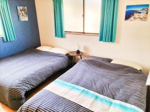two beds sitting next to each other in a bedroom at さくらVillaCOAST in Futtsu