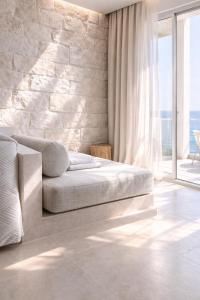 a bedroom with a bed and a stone wall at Gloria Luxury Suites in Kallithea Halkidikis