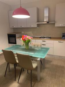 a kitchen with a table with a vase of flowers on it at Casa Pulverun in Domodossola
