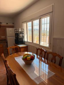 a dining room table with a bowl of fruit on it at Casa rural Cristina- Piscina climatizada in Málaga +14 photos
