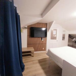 a bedroom with a bed and a flat screen tv at Top Studio Vincennes Centre - SV75 in Vincennes