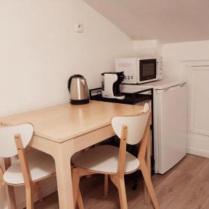 a kitchen with a wooden table with chairs and a microwave at Top Studio Vincennes Centre - SV75 in Vincennes