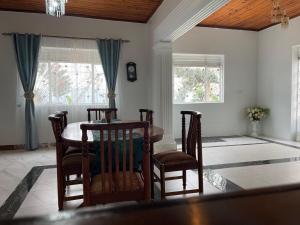 a dining room with a table and chairs and windows at Angel's place in Kabale