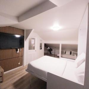 a bedroom with a white bed and a black wall at Top Studio Vincennes Centre - SV75 in Vincennes