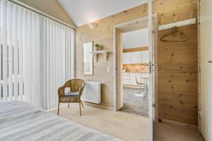 a bedroom with a bed and a chair and a bathroom at 740-Hvide-Sande-Slusen-40 in Hvide Sande