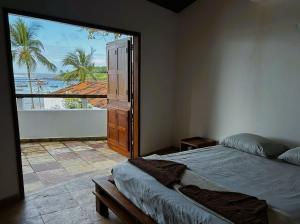 a bedroom with a large window with a view of the ocean at Casaboa Casarão Boutique Orla in Itacaré