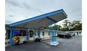a gas station with a blue roof at Holiday Motel Ocala Downtown I-75 in Ocala