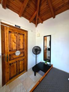 a room with a wooden door and a table at Off Grid Romance in Samos in Ireon